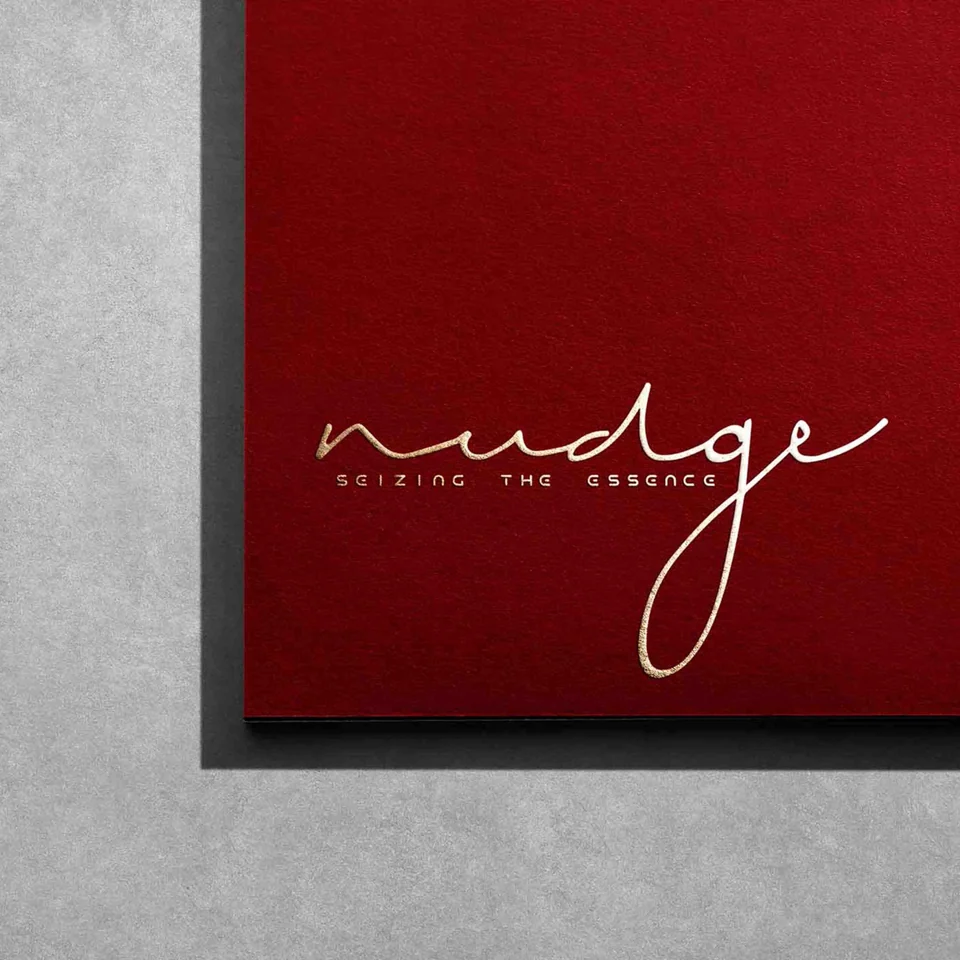 Fine white Nudge script wordmark on a deep red square panel