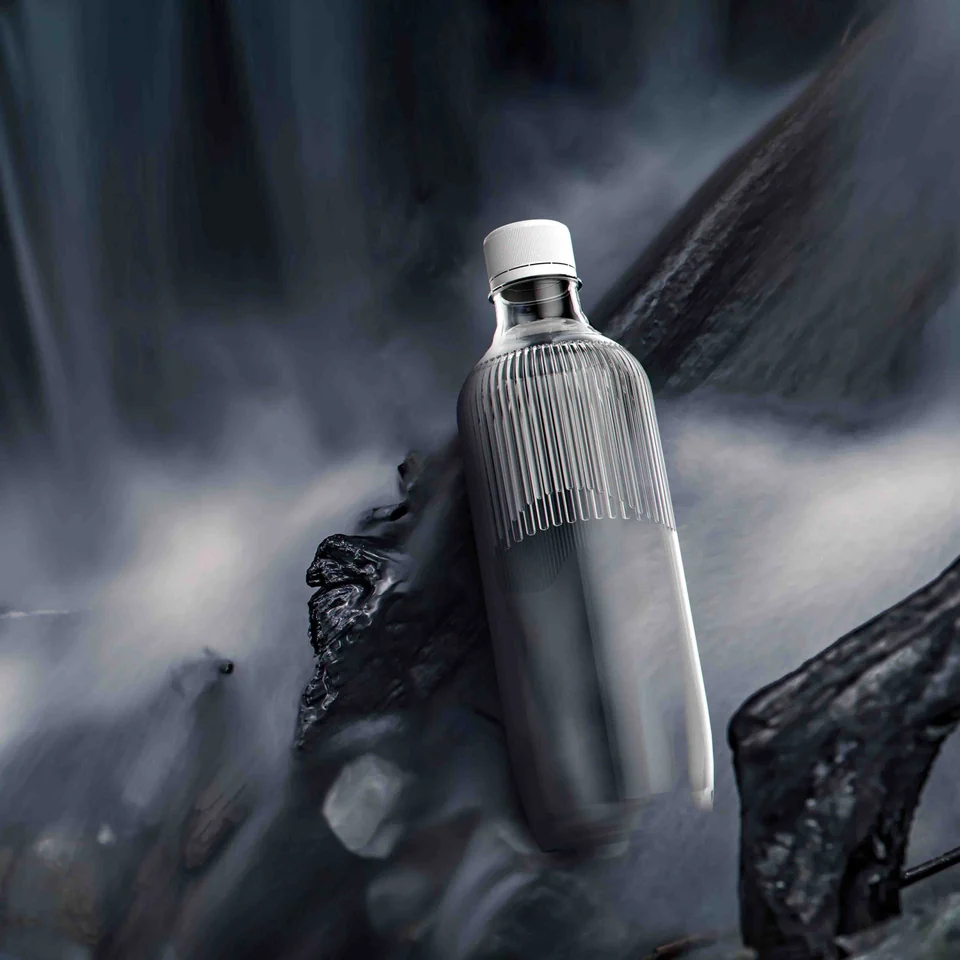 Ribbed Heavenly Curtain bottle resting on dark rocks beside flowing water